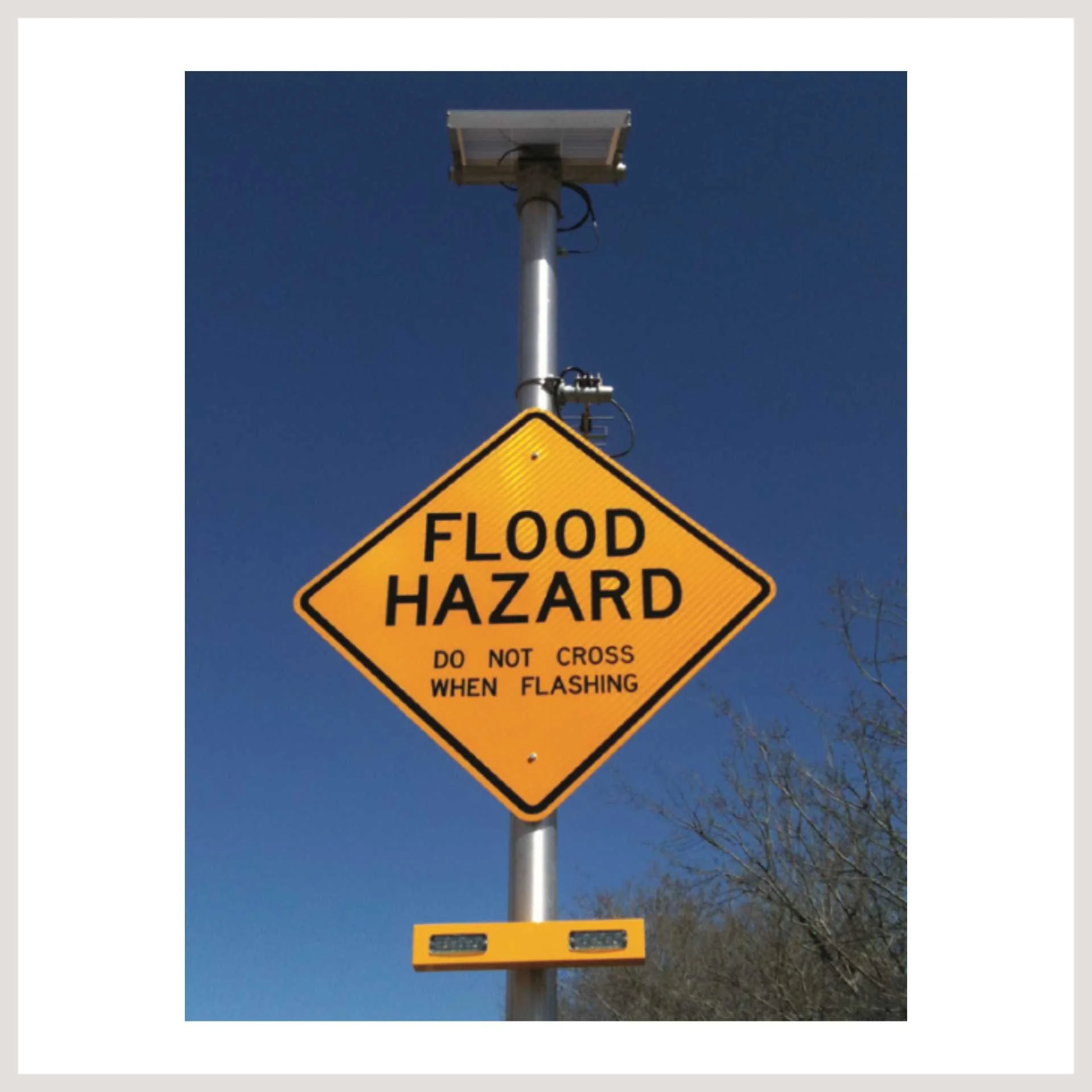 A flood hazard sign mounted on a pole, warning of potential flooding in the area.