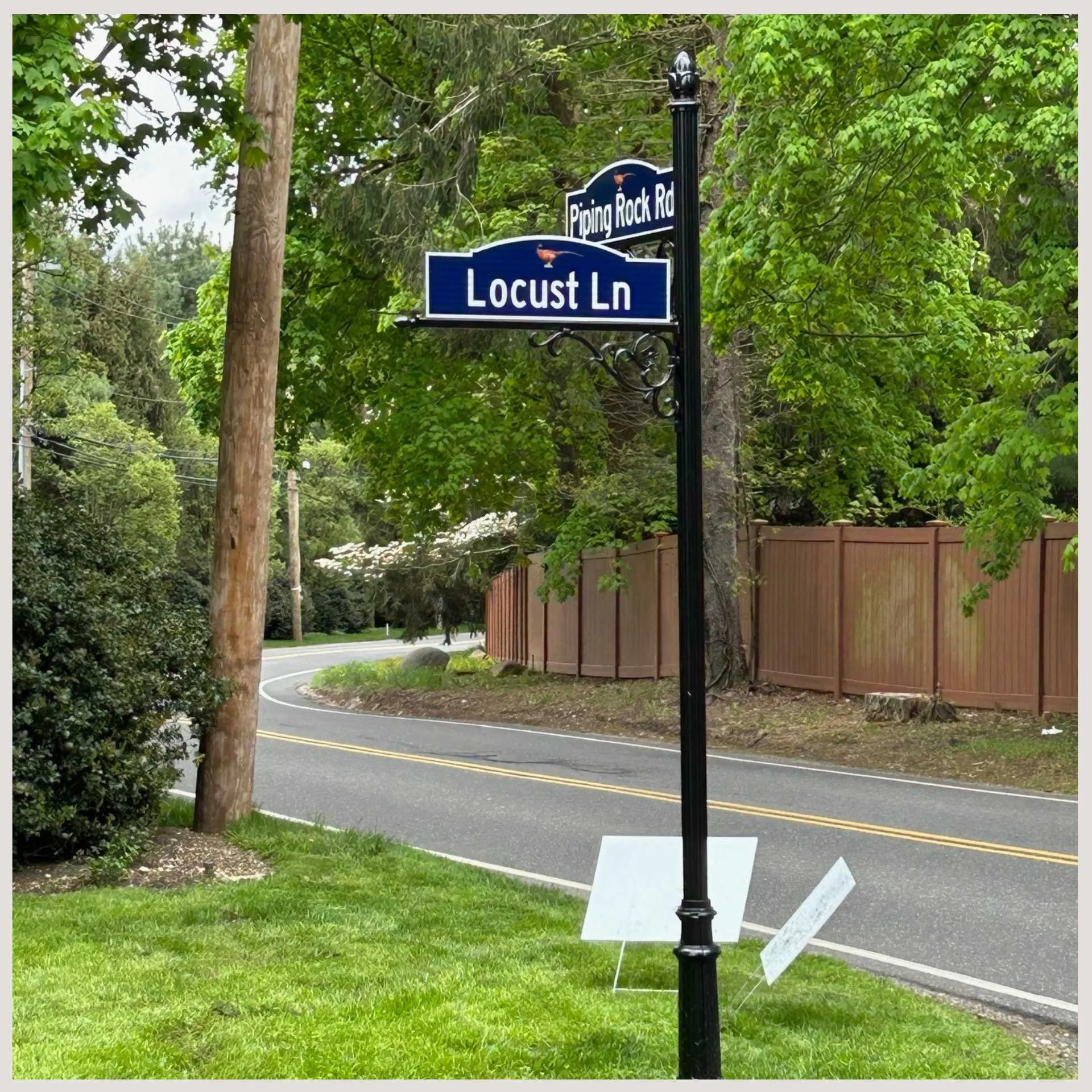 A street sign on a pole indicating "Locust" with additional road signs visible in the background.