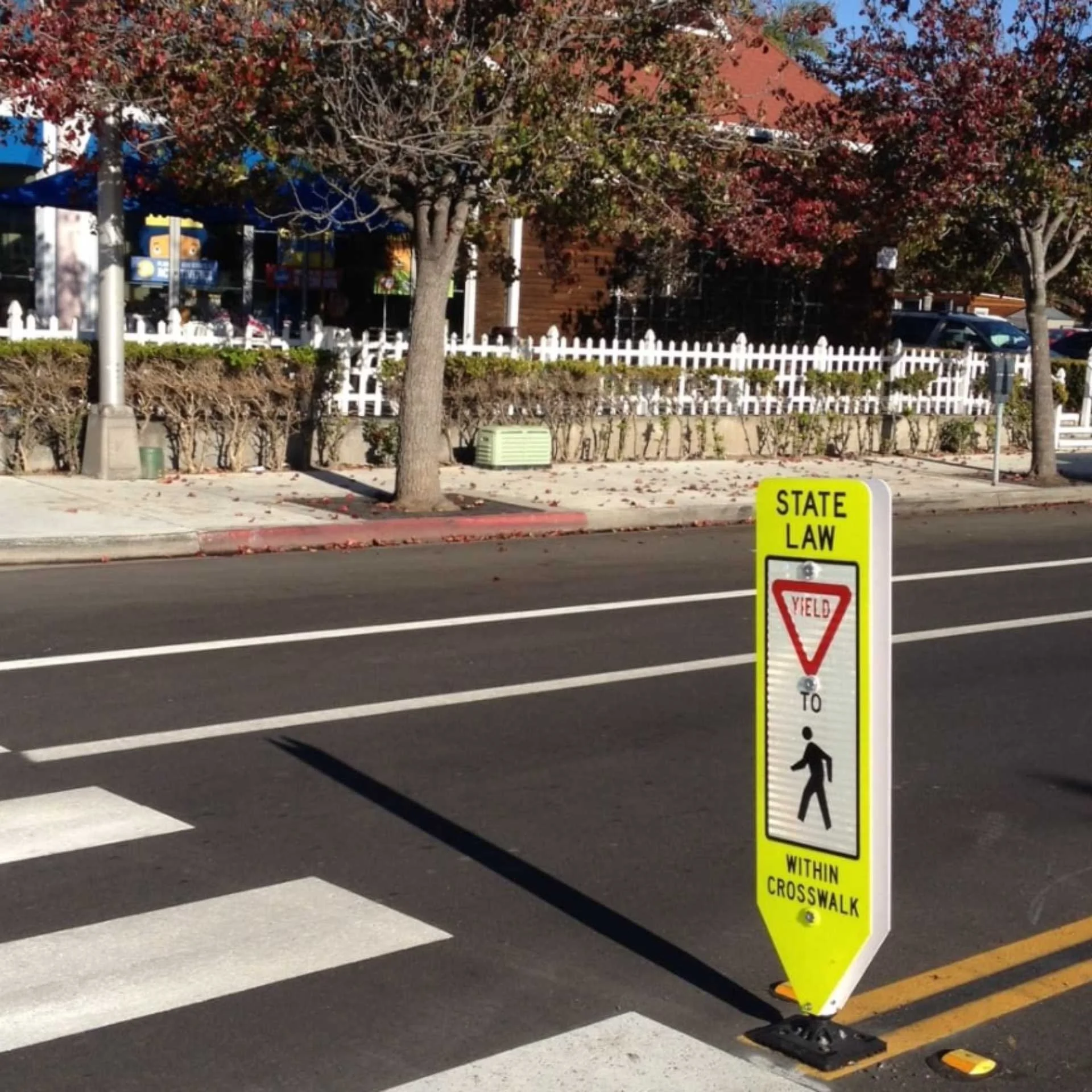 A street sign positioned on the roadside, indicating directions or information for drivers and pedestrians.