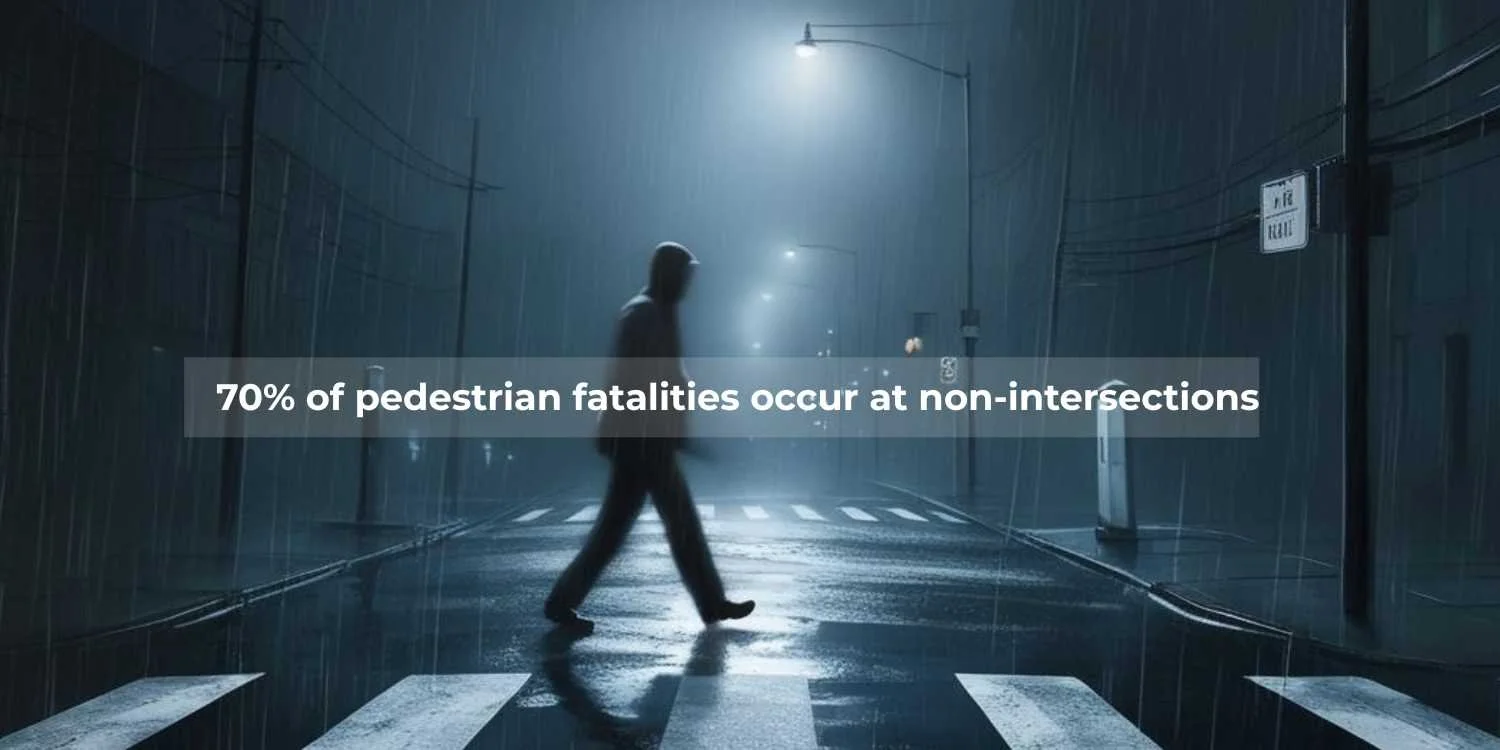 man walking across a street in the dark