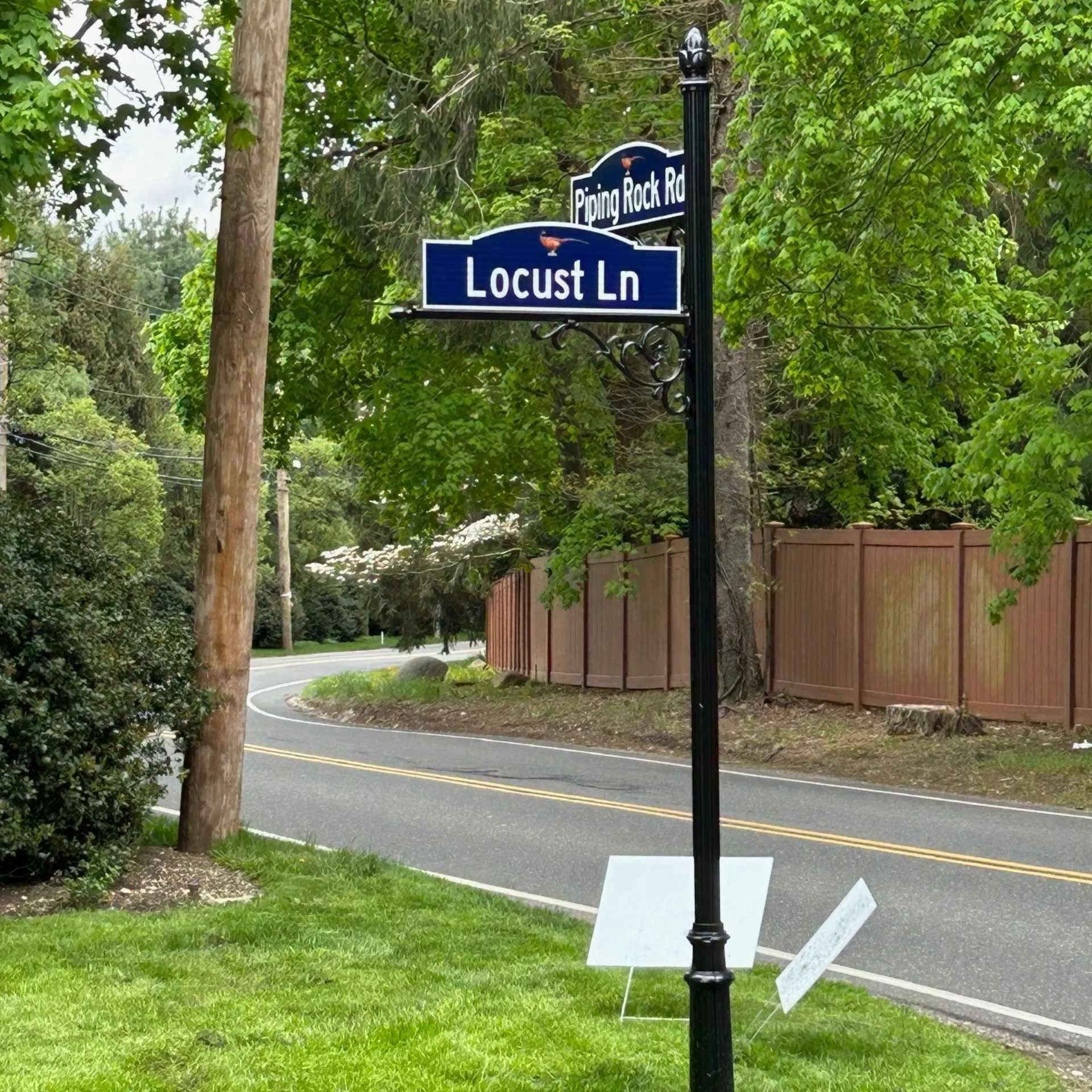 A street sign displaying the street name alongside a sign indicating a nearby business establishment.