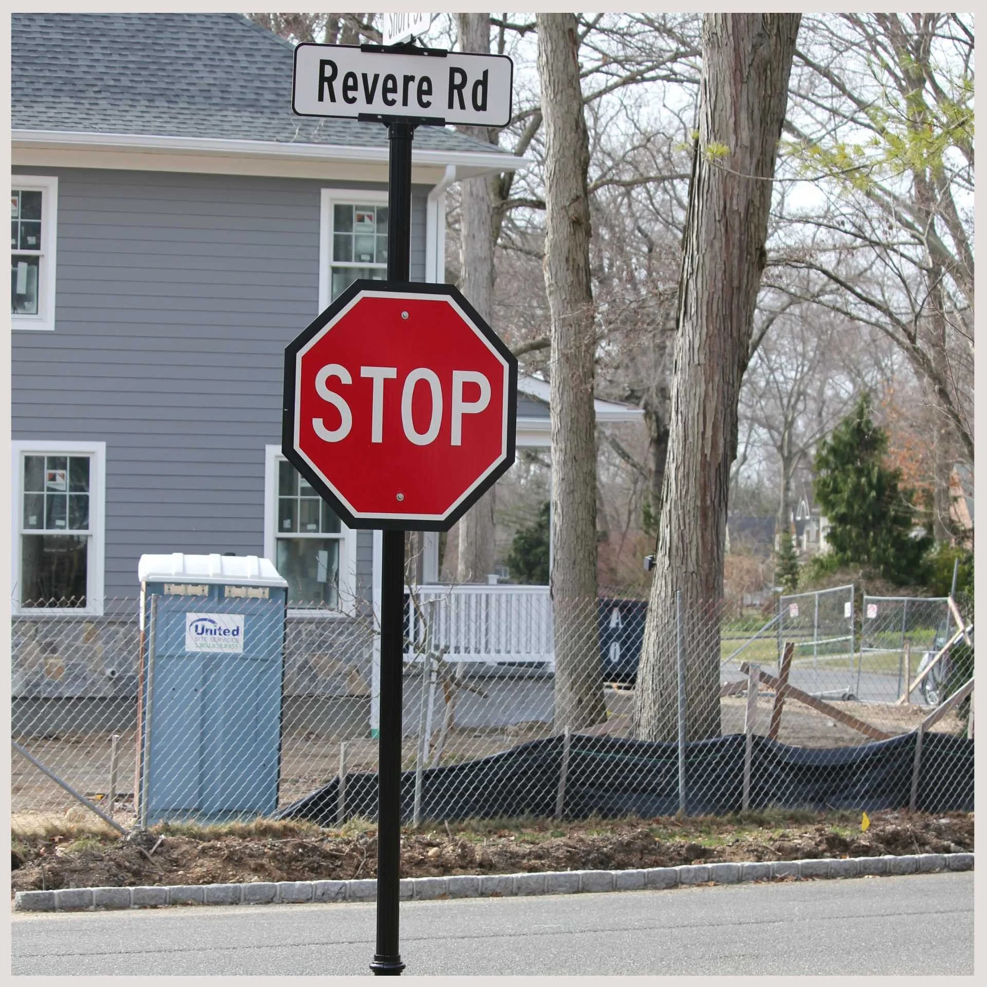 street sign showing "revere road" at the top and a stop sign in the middle on the same post