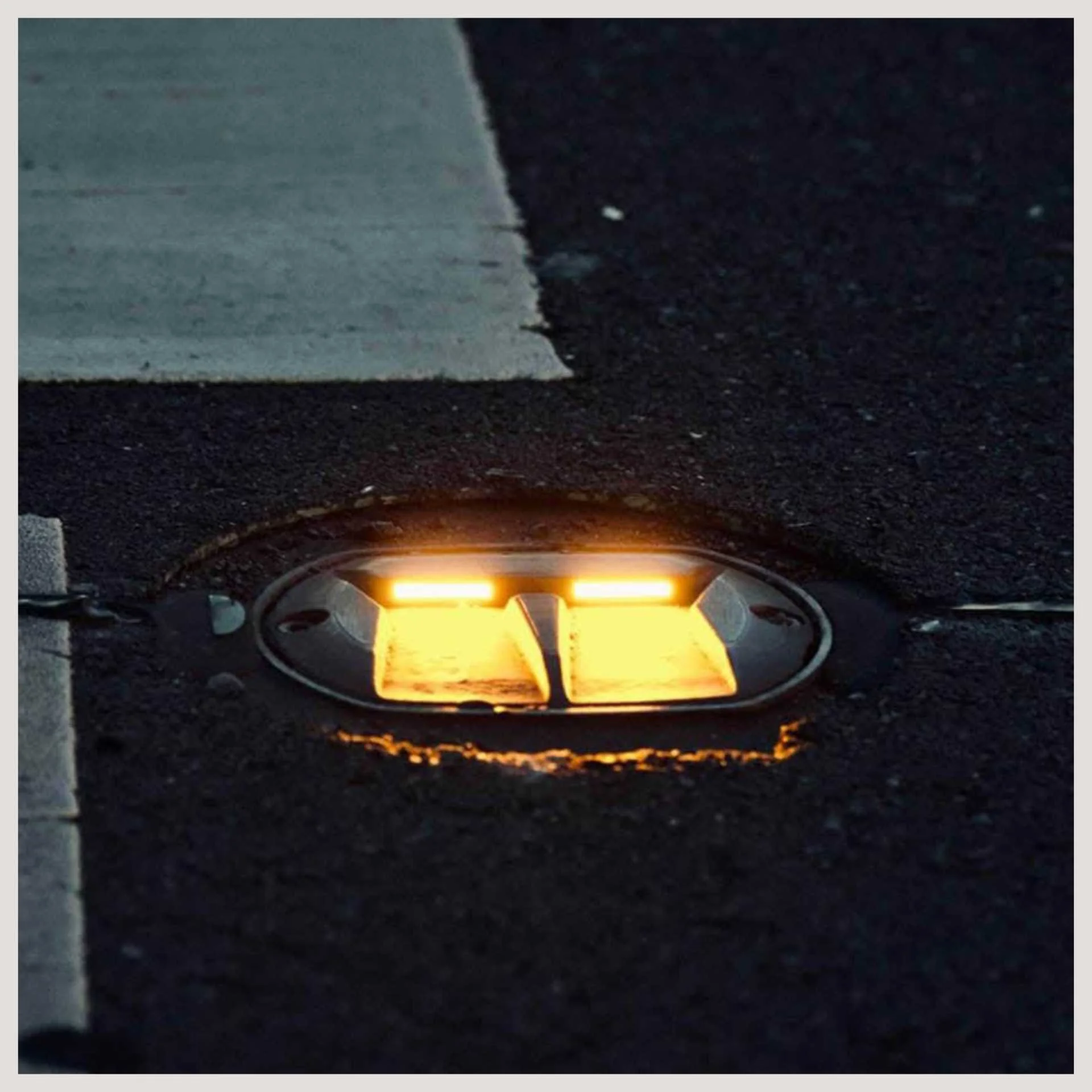 A yellow light illuminates the ground, part of the In-Road Warning Light System (IRWL) for enhanced visibility.