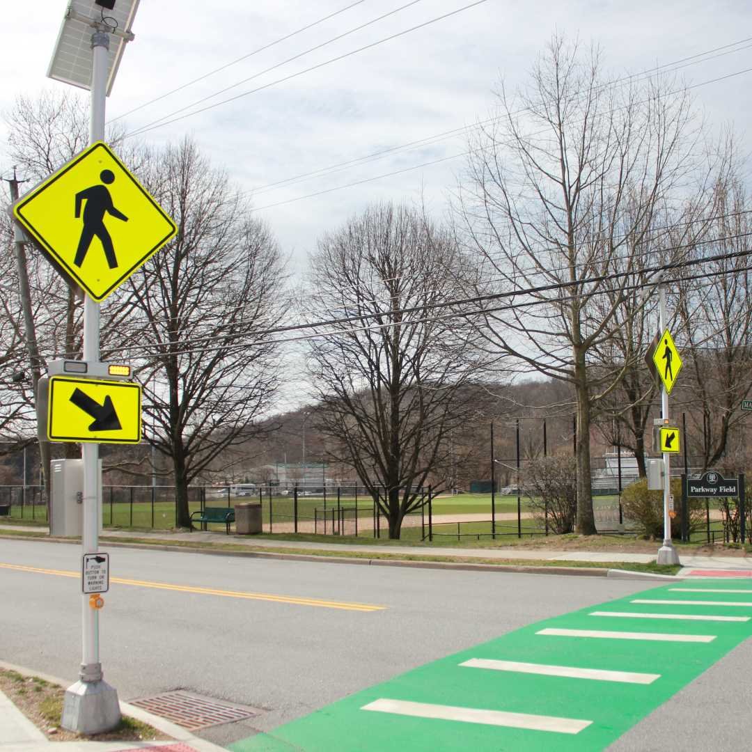  A street scene featuring a crosswalk and a "walk" sign, indicating pedestrian right of way.