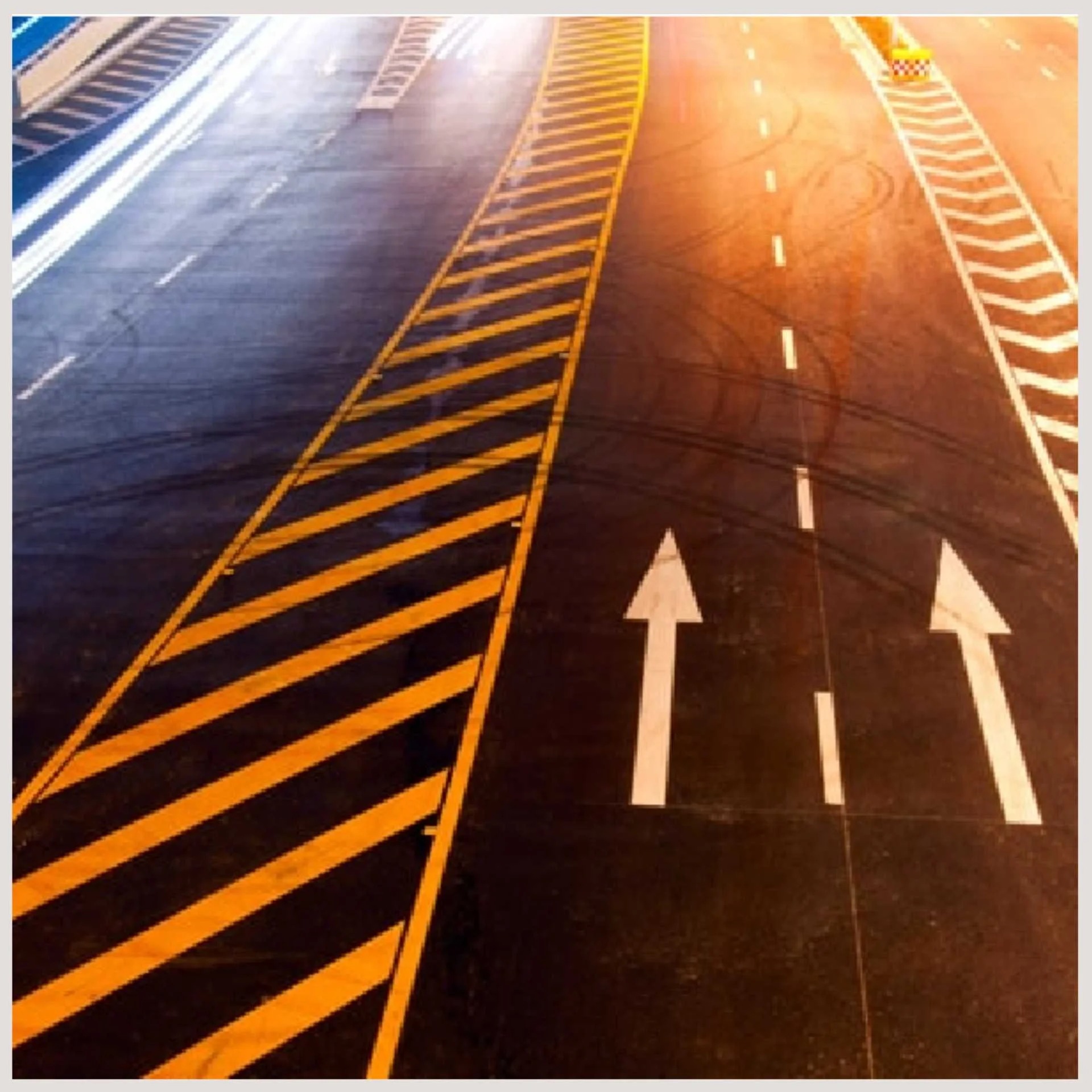 A road featuring distinct yellow and white lines along with directional arrows guiding traffic flow.