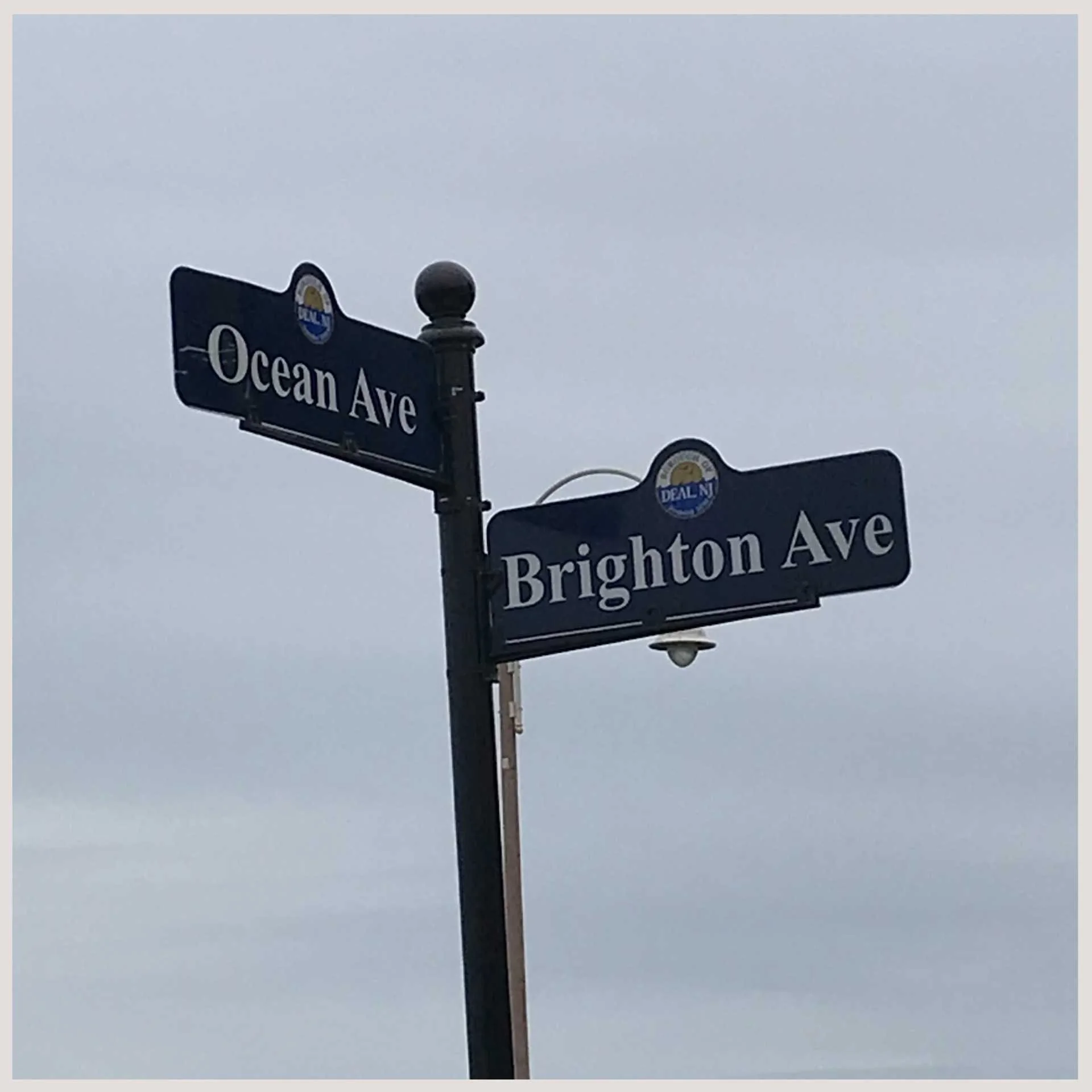 A pole displaying two street signs, "ocean ave" and "brighton ave" providing directional guidance for drivers and pedestrians.