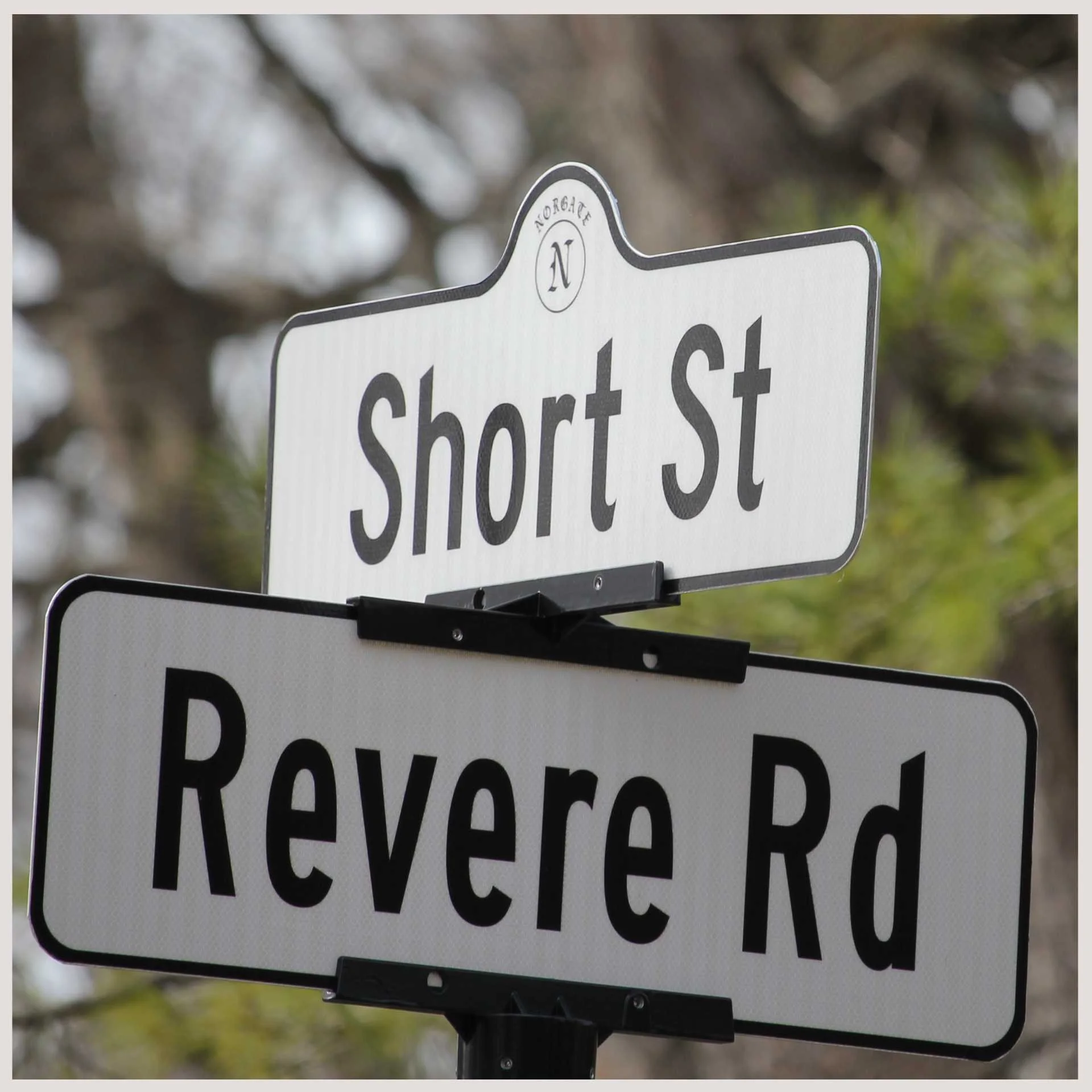A street sign displaying "short street" and "revere road" , indicating directions for drivers and pedestrians.