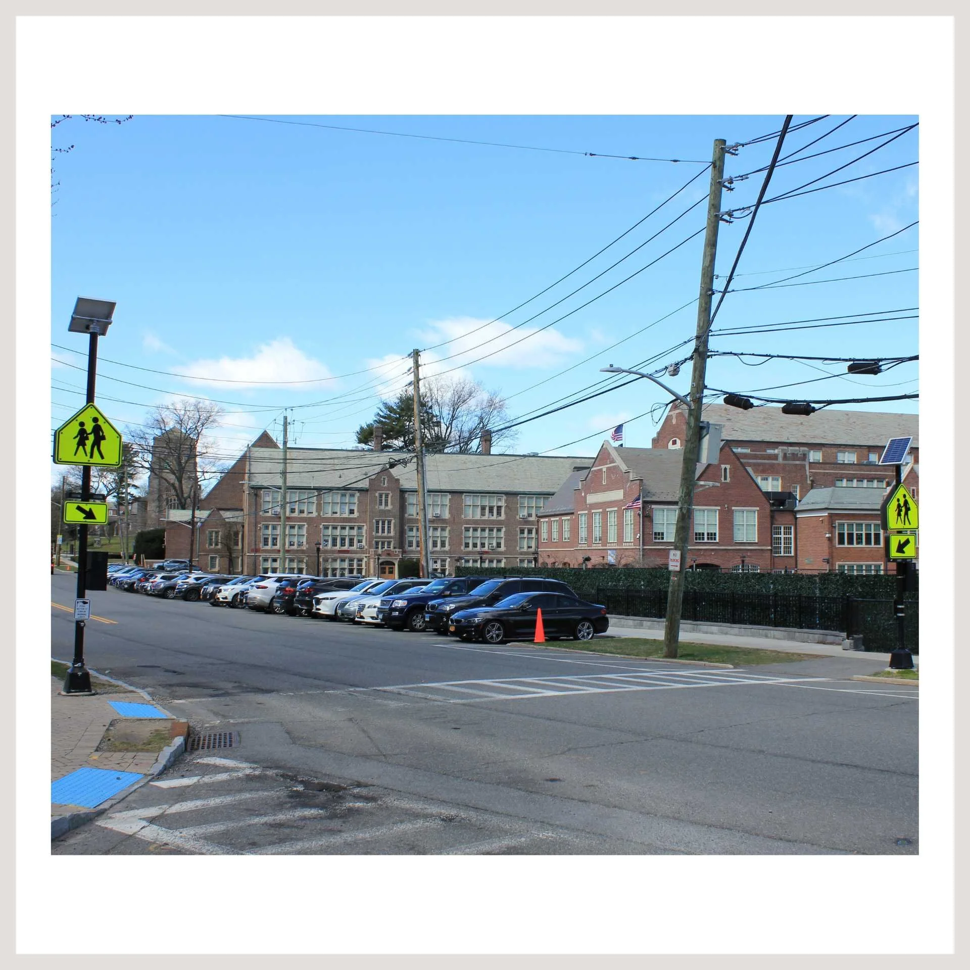A street view with multiple signs and cars, showcasing Rectangular Rapid Flashing Beacon Systems
