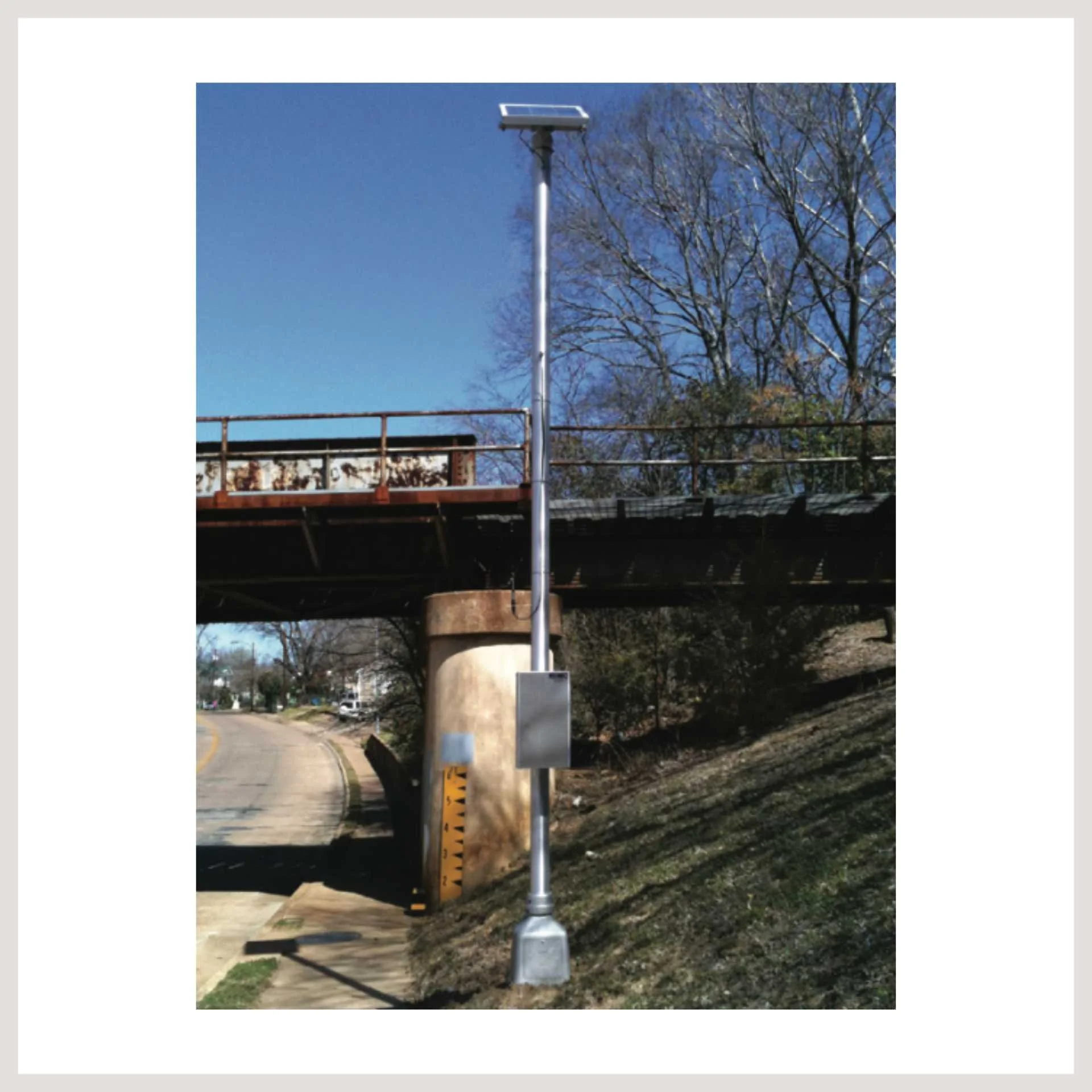 pole from flood warning system on the side of a road